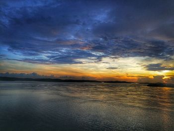 Scenic view of sea against dramatic sky during sunset