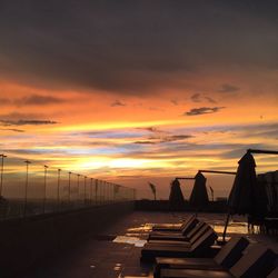 Silhouette railing against sky during sunset