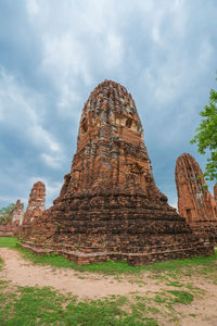 Low angle view of old temple against cloudy sky