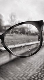 Close-up of sunglasses on mirror against sky