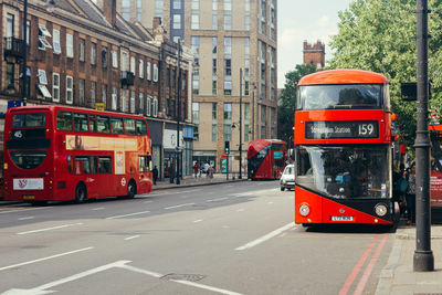 Traffic on road by buildings in city