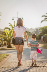 Rear view of women walking on footpath