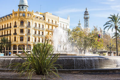 Fountain in city against sky