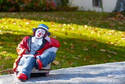 Close-up of clown on retaining wall at park