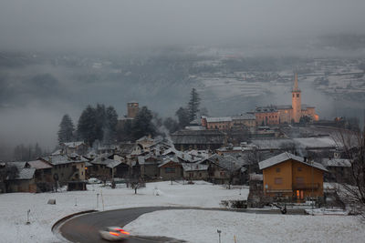 Buildings in town against sky during winter