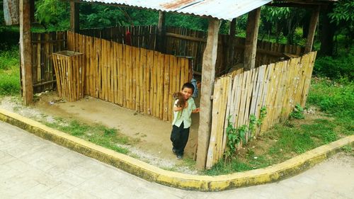 Portrait of man standing on wooden fence