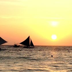 Boat sailing in sea at sunset