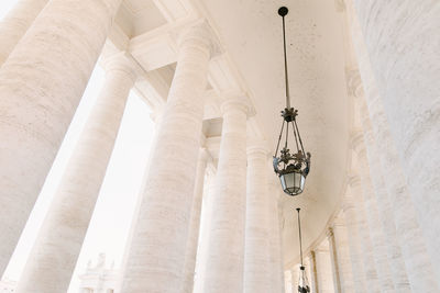 Low angle view of electric lamp hanging on ceiling of building