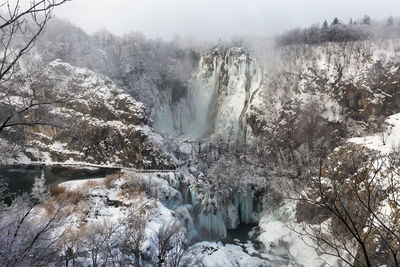Scenic view of waterfall in forest during winter