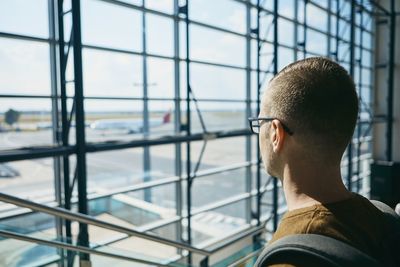 Man looking airplane through window