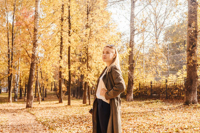 Woman standing against trees in park during autumn