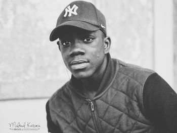 Portrait of young man standing against wall