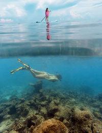 Young women have a fun in ocean, underwater view