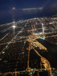 Aerial view of illuminated cityscape against sky at night