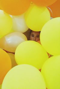 Portrait of girl amidst yellow balloons