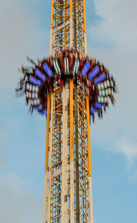 Blurred motion of amusement park ride against sky