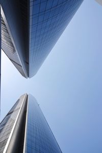 Low angle view of modern buildings against clear blue sky