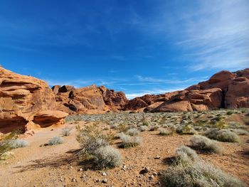 Rock formations on landscape against blue sky