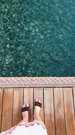 Low section of man standing in swimming pool