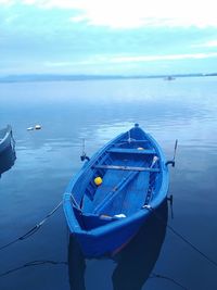 Sailboat moored on sea against sky