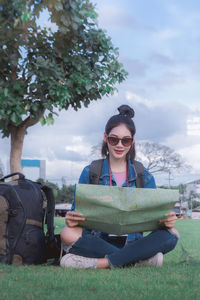 Young woman wearing sunglasses sitting outdoors