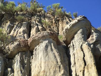 Low angle view of rock formation against clear blue sky