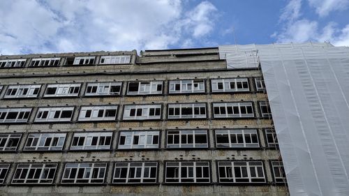 Low angle view of building against cloudy sky