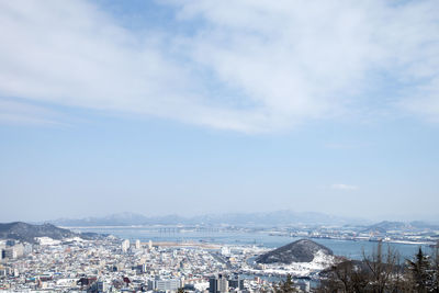 Aerial view of buildings in town against sky