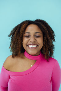 Smiling young woman against blue background