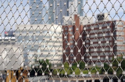 The skyline of boston, ma, seen through a metal fence