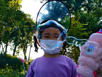 Portrait of boy with bubbles in park