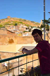 Portrait of man leaning on railing