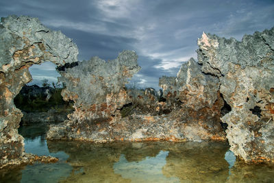 Rock formations in sea against sky