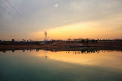 Scenic view of factory against sky during sunset