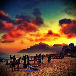 People at beach during sunset