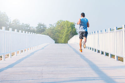 Rear view of man on footbridge