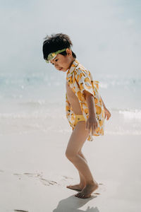 Side view of boy walking at beach