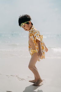 Side view of young woman with sunglasses on beach