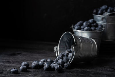 Close-up of fruits in jar on table against black background