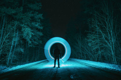 Full length of woman standing on illuminated tunnel