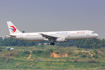 Airplane on field against sky