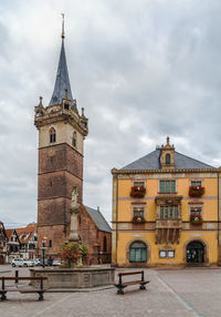 View of buildings in city against cloudy sky