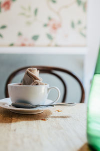 Empty coffee cup with crumpled napkin on table