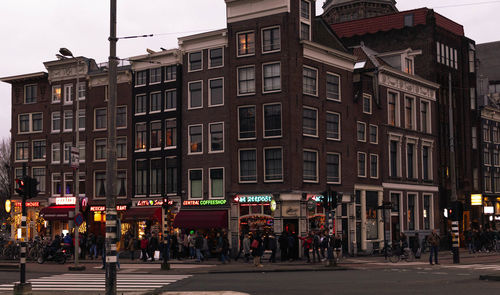 Group of people on city street against buildings