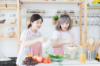 Smiling girl holding food while standing on table
