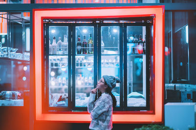 Full length of woman standing by window at home