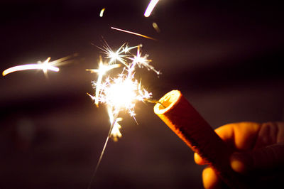 Close-up of hand holding sparkler at night