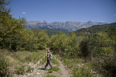Woman standing on mountain against sky
