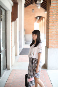 Portrait of woman standing on corridor