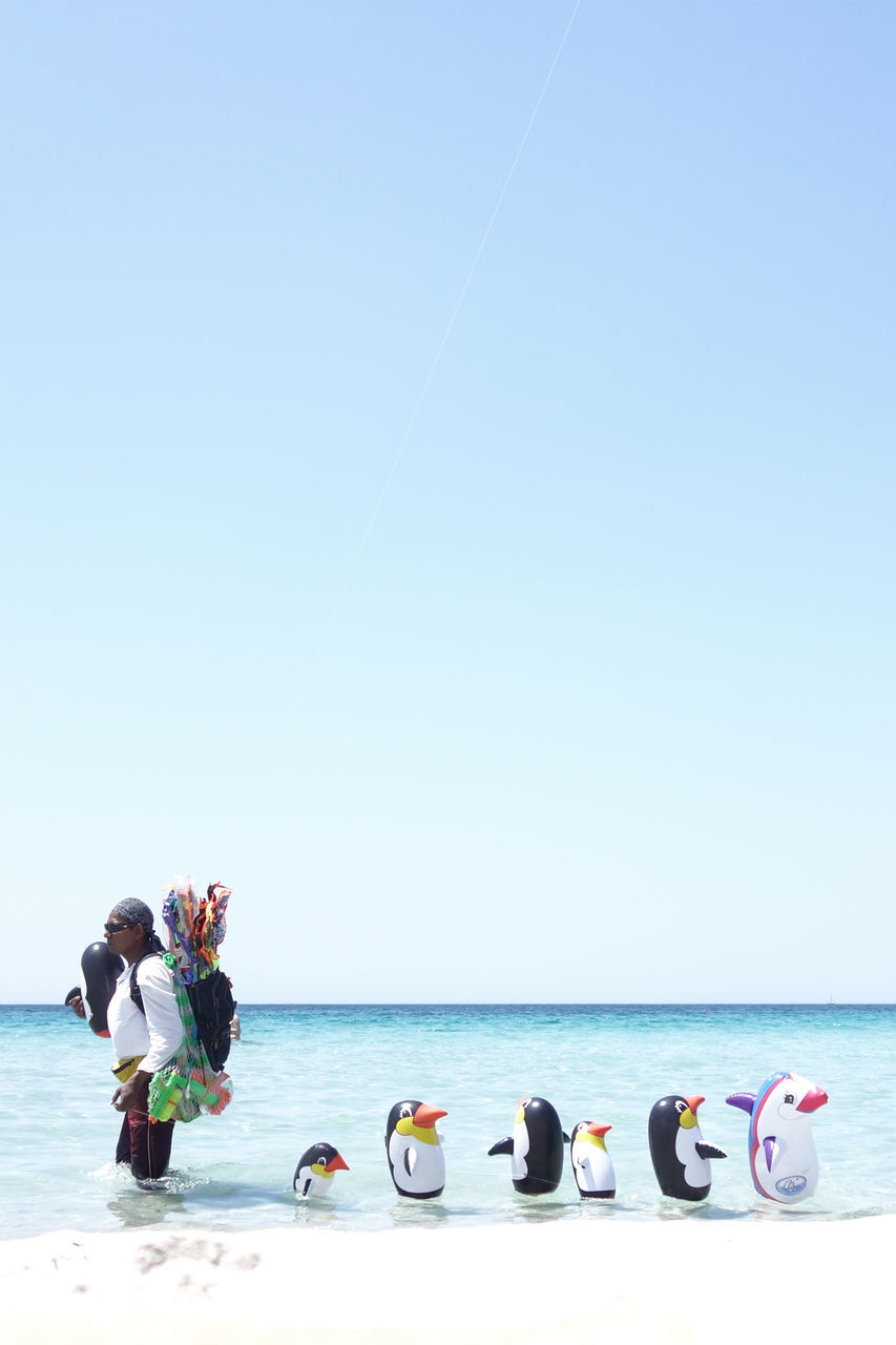 copy space, clear sky, sea, water, horizon over water, beach, lifestyles, leisure activity, men, vacations, person, large group of people, shore, beauty in nature, togetherness, nature, transportation, blue, sitting